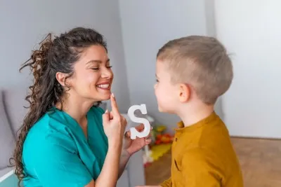 Une femme aide un enfant à prononcer un mot